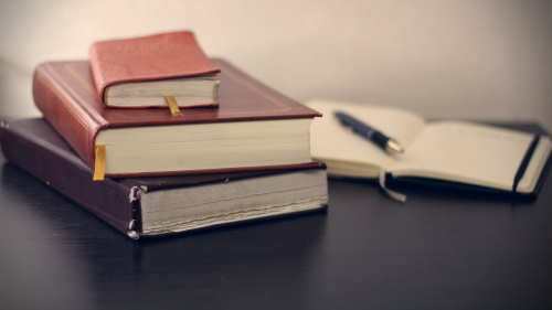Trois livres sur un bureau de Boulet Desrosiers Boivn